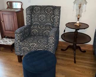 Blue Patterned Accent Armchair — Comfortable upholstered accent armchair in a navy-and-ivory geometric/medallion pattern with squared arms and a slightly winged back. Solid wood block legs and a medium-firm seat make it suitable for a reading corner or living room; included in photos is a separate round tufted navy ottoman (seen in images) but ottoman not guaranteed included. Fabric shows light, even wear consistent with normal use and no visible tears or stains from photos. Measures compactly for small spaces and pairs well with traditional or transitional decor.