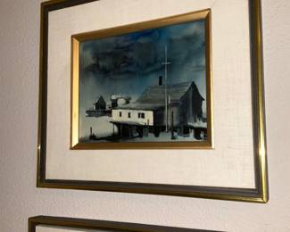Framed Harbor Watercolor Print — Small framed harbor watercolor or print in a gilt inner frame with fabric matting and outer brass-toned frame. The artwork shows a waterside building and pilings with moored boats under a moody sky; medium appears to be watercolor or a printed reproduction. Frame and mat show light surface wear and a small scuff on the lower mat edge visible in photos; overall ready to hang. Outer framed piece measures approximately 18 x 14 inches; image visible area about 8 x 6 inches.