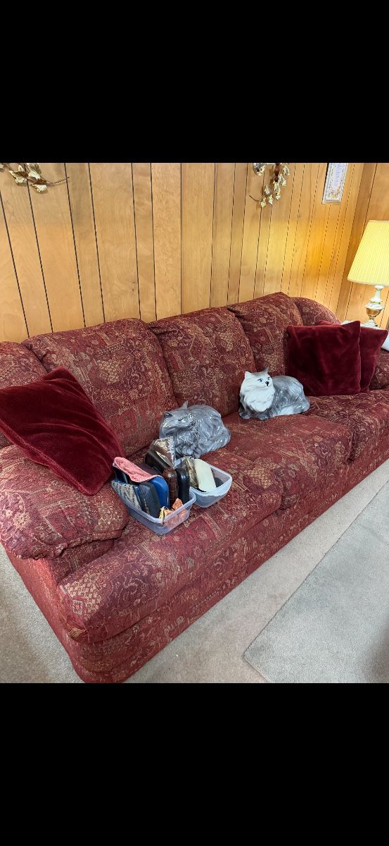 Vintage Alberta Cat molds sitting on a clean couch that has a matching recliner