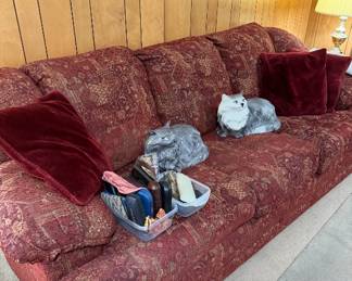 Vintage Alberta Cat molds sitting on a clean couch that has a matching recliner