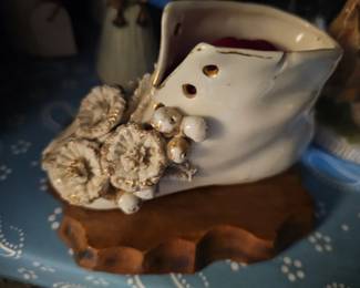 This is a mid-20th century decorative ceramic baby shoe with applied flowers.