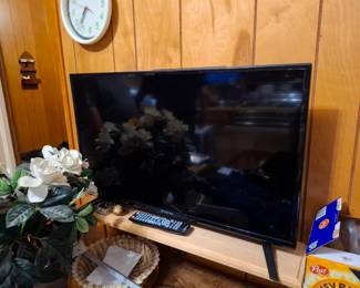 Black Flat-Screen LED Television with Remote Control, Home Entertainment TV, Wood Media Stand, Decorative Artificial Floral Arrangement & Wicker Basket