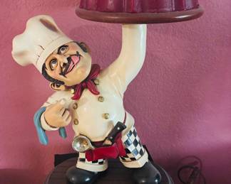 Height challenged chef serving a cake.