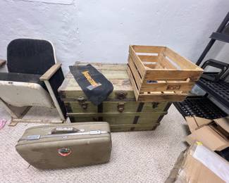vintage green wooden storage trunk with metal latches, topped with a small wooden crate and a black Harley-Davidson pouch.