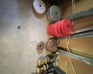 collection of vintage exercise weight plates and dumbbells