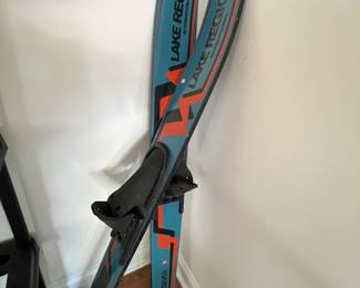 a pair of blue and orange alpine skis leaning against a wall, which appear to resemble the Rossignol Arcade 88 all-mountain skis