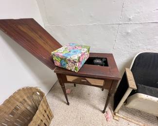 vintage wooden sewing machine cabinet with a dark finish and an extended fold-out leaf top. mid-20th-century model Singer