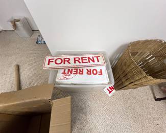 stack of red-and-white plastic "For Rent" signs,