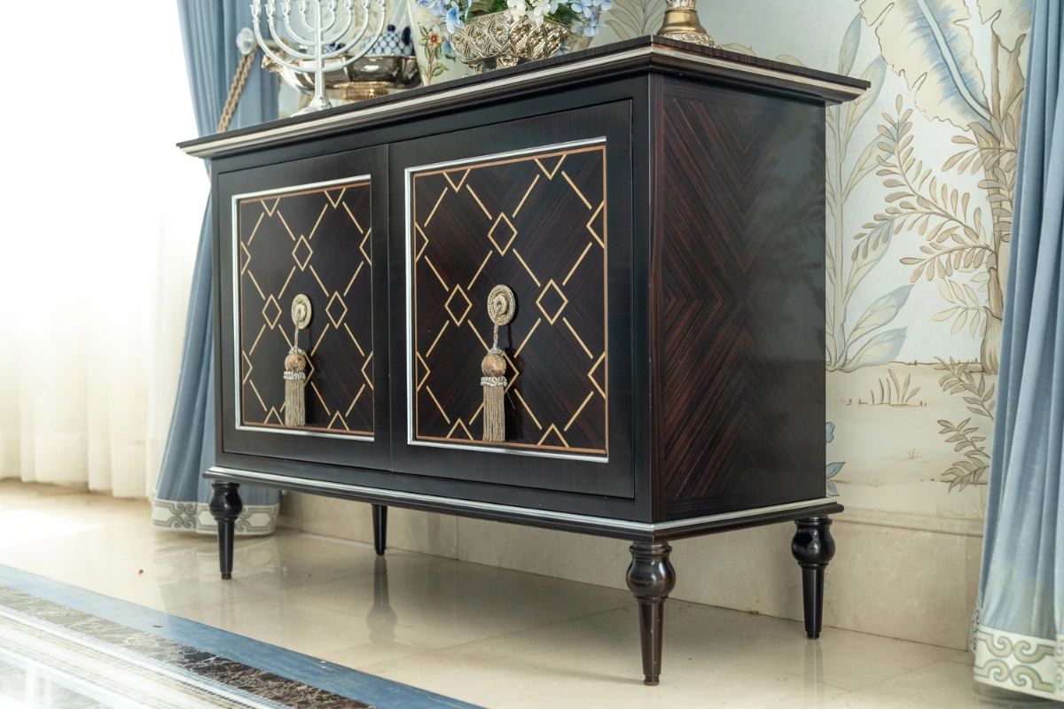 Elegant black lacquer cabinet with decorativve gold geometric detailing  ornate tassel hardware 