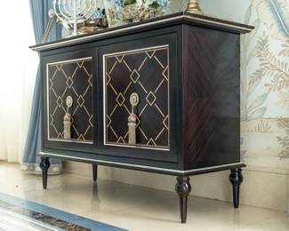Elegant black lacquer cabinet with decorativve gold geometric detailing  ornate tassel hardware 