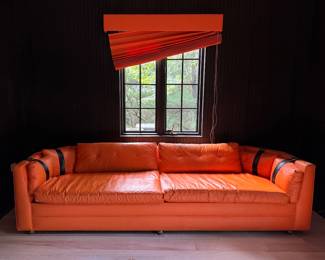 Hermes-Orange Color Vinyl Upholstered Sleeper Sofa. Slight Tear on Fabric. Measures 106" W x 36" D. Photo 1 of 6.