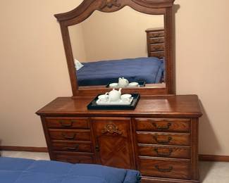 Traditional Oak Queen Bedroom Suite — $750 Includes queen bed, dresser with large mirror, tall chest, and 1 matching nightstand. Excellent condition with beautiful carved detailing and decorative hardware.