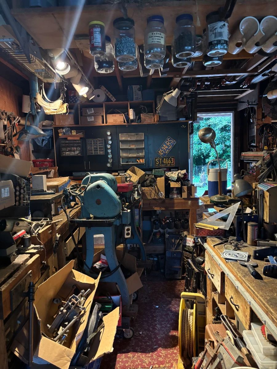 Garage, full of tools, metal drawers and storage containers, and vintage tool parts in boxes