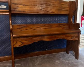 Wooden bench with scalloped back, scroll shaped armrests and an arched front apron.