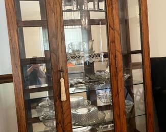 Classic wood curio display cabinet with warm finish and glass paneled doors.