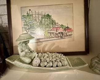 Asian celadon glazed or jade style long boat with figurine in a traditional conical hat with the days bounty