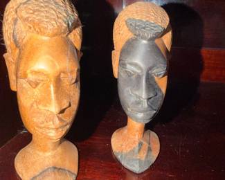 pair of vintage hand-carved wooden head bust sculptures featuring a striking contrast between natural wood and dark-stained finishes