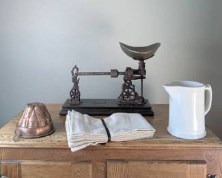 Antique balance scale with vintage kitchen and serving pieces.