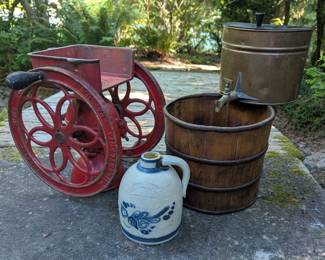 Antique double-wheel coffee grinder, wood barrels and stoneware.