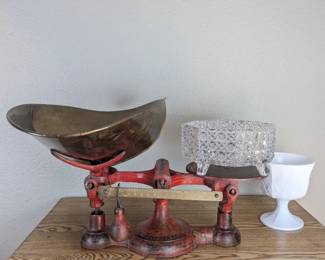 Vintage scale with glassware and decorative pieces.