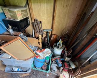 Mixed storage-unit contents with vintage-style pull wagon, croquet set, tools, small appliances, furnishings, and boxed household goods - additional view