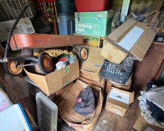 Mixed storage-unit contents with vintage-style pull wagon, croquet set, tools, small appliances, furnishings, and boxed household goods - additional view