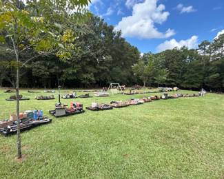 Outdoor auction rows with farm, workshop and household lots