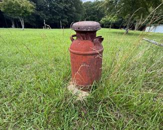 Weathered red dairy-style milk can with lid