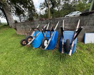 Group of three blue single-wheel wheelbarrows, plus loose panel