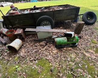Weathered wood-sided utility trailer with mixed salvage and equipment contents