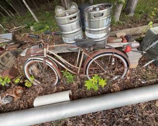 Outdoor salvage group with two cruiser bicycles, beverage kegs, gas cylinders, ducting and assorted equipment