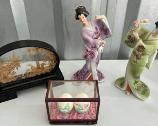 Lot 43: Geisha figurine, oval landscape plaque, and two painted eggs in glass display
