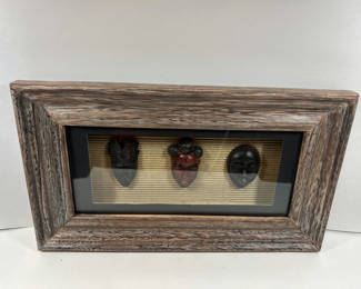 Lot 84: Three carved masks in a rustic framed display