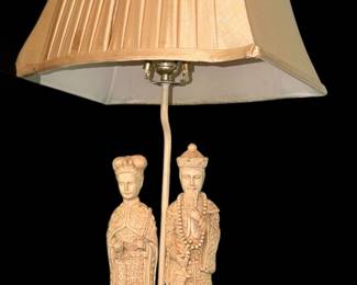 vintage Chinese Emperor and Empress figural table lamp featuring carved faux-ivory resin figures mounted on a round wooden base beneath a pleated gold fabric shade./pair
