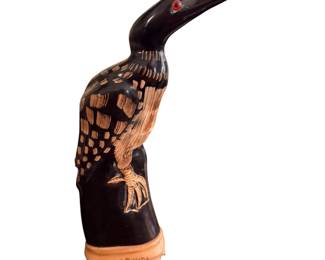 vintage hand-carved water buffalo horn bird figurine, resembling a loon or water bird with red glass or bead eyes, mounted on a base  "Bastf & Canada