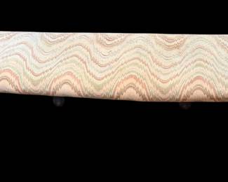 long upholstered bench featuring a wavy patterned fabric top and turned wooden legs