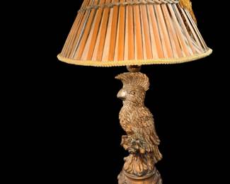 vintage sculptural cockatoo table lamp featuring a carved bird base and a pleated bamboo-style shade with tassel trim.