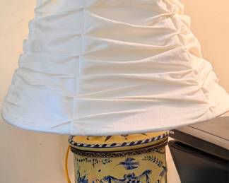 vintage-style yellow and blue ceramic table lamp featuring ornate mythical figures and decorative metal feet.
