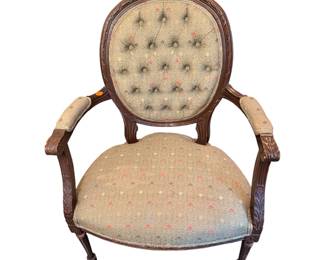 vintage French-style medallion-back armchair featuring elegant button tufting and an intricately carved dark wood frame.