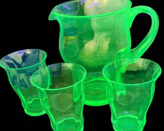 vintage green uranium glass lemonade pitcher and tumbler set that glows brightly under ultraviolet light