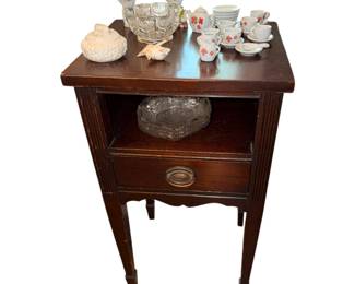 vintage Federal-style mahogany end table featuring an open middle shelf, a single drawer with a brass pull, and classic tapered legs