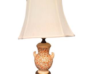 Pair of Asian-style porcelain vase table lamp featuring a cream background with an intricate hand-painted orange and dark swirling floral scroll pattern and applied side handles, topped with a flared off-white rectangular shade.
