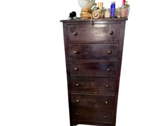 tall wooden chest of drawers finished in a dark stain, featuring six stacked drawers with matching round wooden knobs.