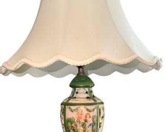 vintage hand-painted porcelain table lamp featuring a green-trimmed urn base with delicate figural artwork and a scalloped cream shade