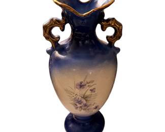 antique-style porcelain double-handled urn vase featuring a cobalt blue and cream gradient with gold-gilt trim and a painted floral motif.
