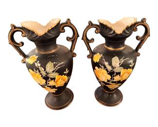 vintage black ceramic or pottery double-handled amphora vases featuring hand-painted yellow or gold floral motifs with gold trim