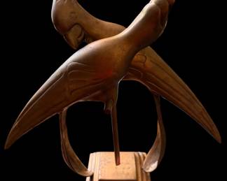 Vintage bronze sculpture depicting two birds in flight or crossing paths, mounted on a stepped tiered base.
