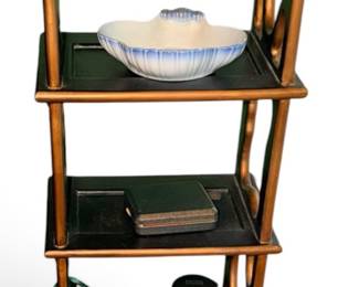 multi-tiered Chinoiserie-style wooden display étagère featuring black and gold-toned finishes with two small storage drawers at the base.
