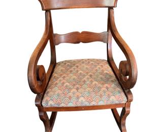 vintage Regency-style wooden armchair featuring distinct scrolled arms and a patterned upholstered seat./rocker
