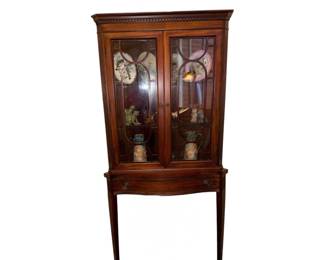 classic antique Georgian-style mahogany corner display cabinet on stand (often matching Edwardian or Federal period reproduction styles), featuring distinctive astragal glazed doors, a bowed lower drawer, and elegant tall, tapered legs.